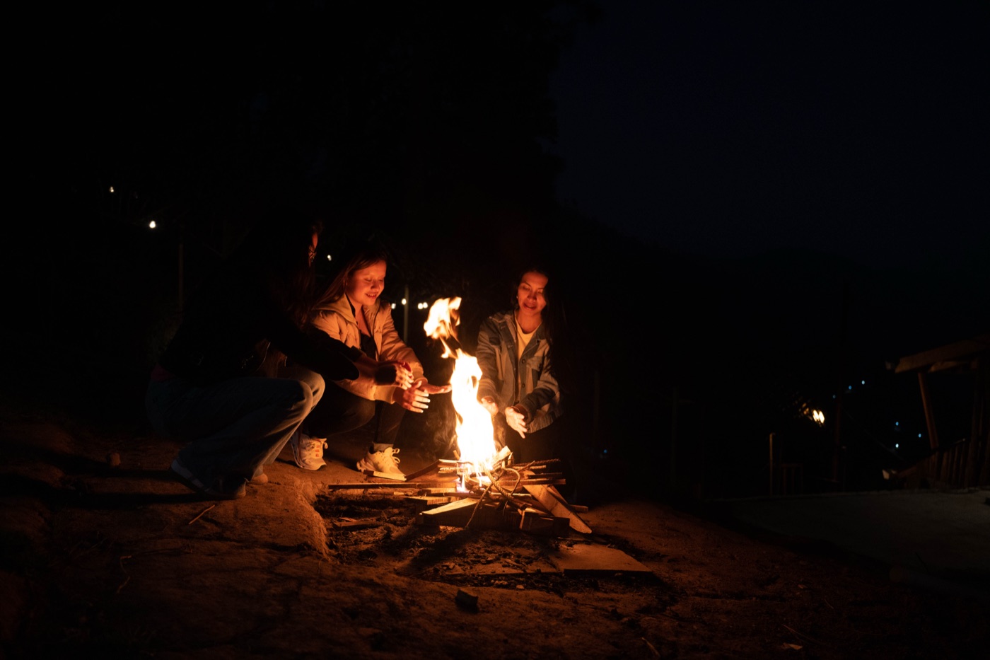 Visitantes reunidos alrededor de una fogata nocturna en Xwan